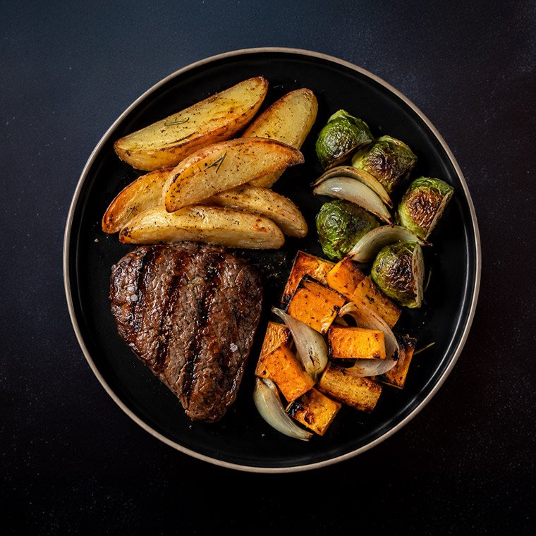 Lomo con romero, papas cuñas y verduras al horno